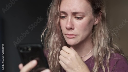 Sad worried woman reading news looking at the smartphone and started crying.