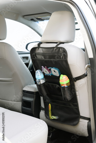 Black car seat organizer for babies, on a car interior photo