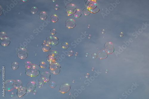 Spectacular bottom-up view to clear blue sky with colorful, airy soap bubbles in the foreground