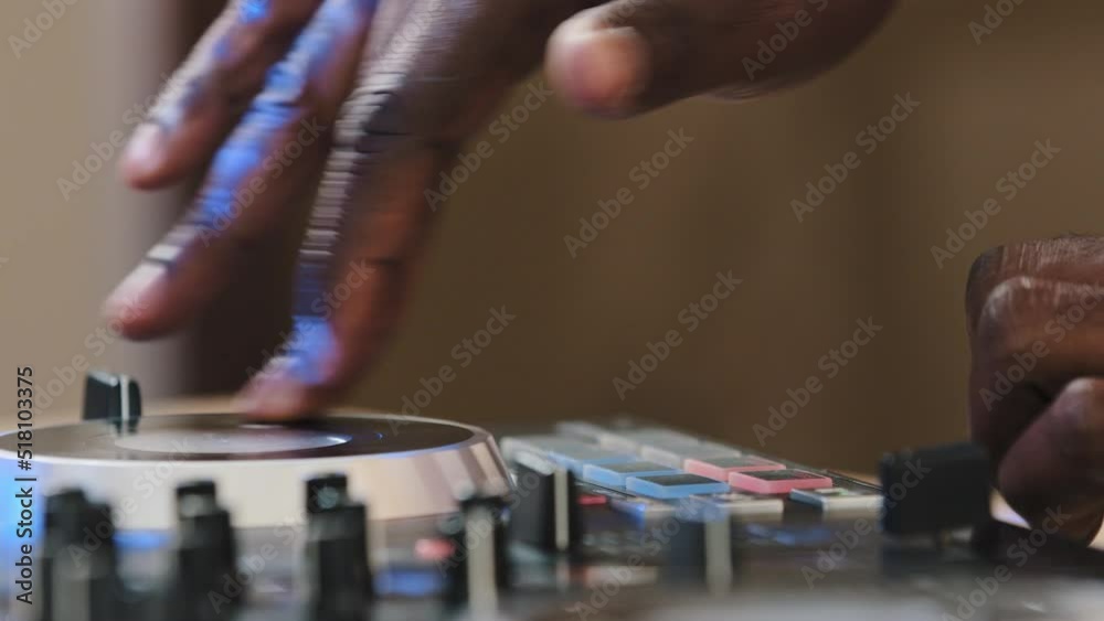 Close-up unrecognizable DJ man spinning record vinyl twist disc using mixer controller desk for playing electronic modern music in club party African male hands touching sliders sound audio recording Close-up unrecognizable DJ man spinning record vinyl twist disc using mixer controller desk for playing electronic modern music in club party African male hands touching sliders sound audio recording