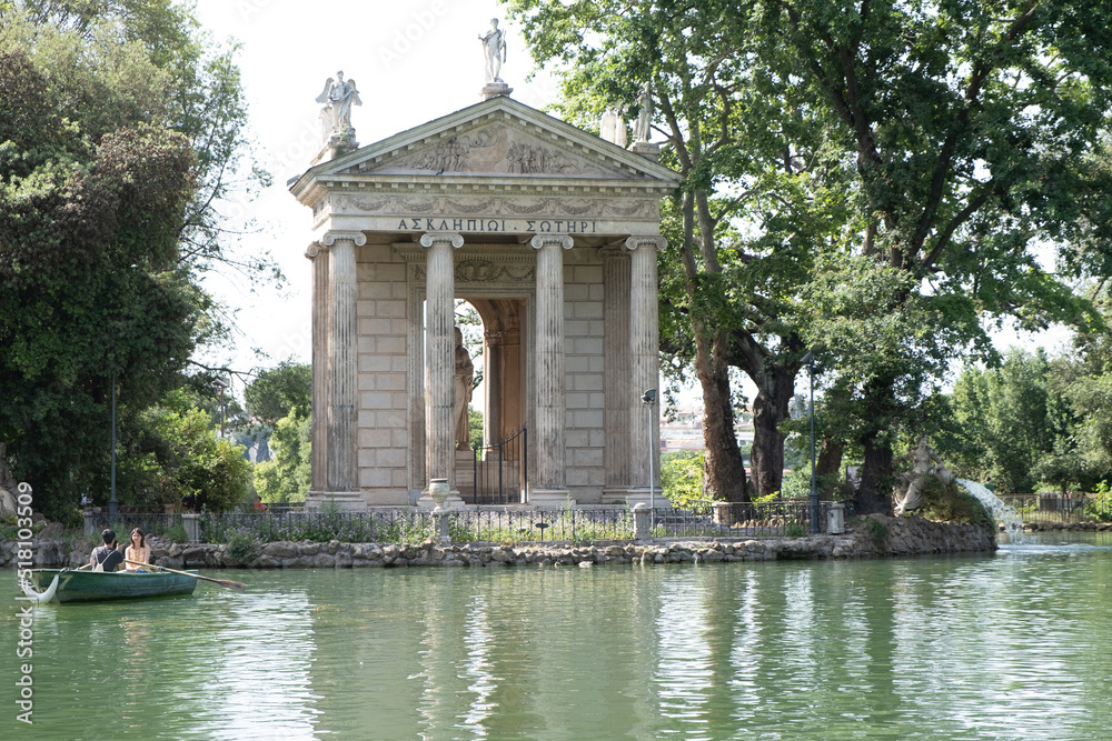 Spectacular view of Villa Borghese (Temple of Esculapio) in Rome with blue sky and green trees in background and water basin in the foreground. Spectacular view of Villa Borghese (Temple of Esculapio) in Rome with blue sky and green trees in background and water basin in the foreground.