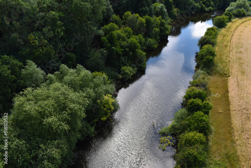 Birds Eye View Over Blue River In Green Forest Woodland With Field