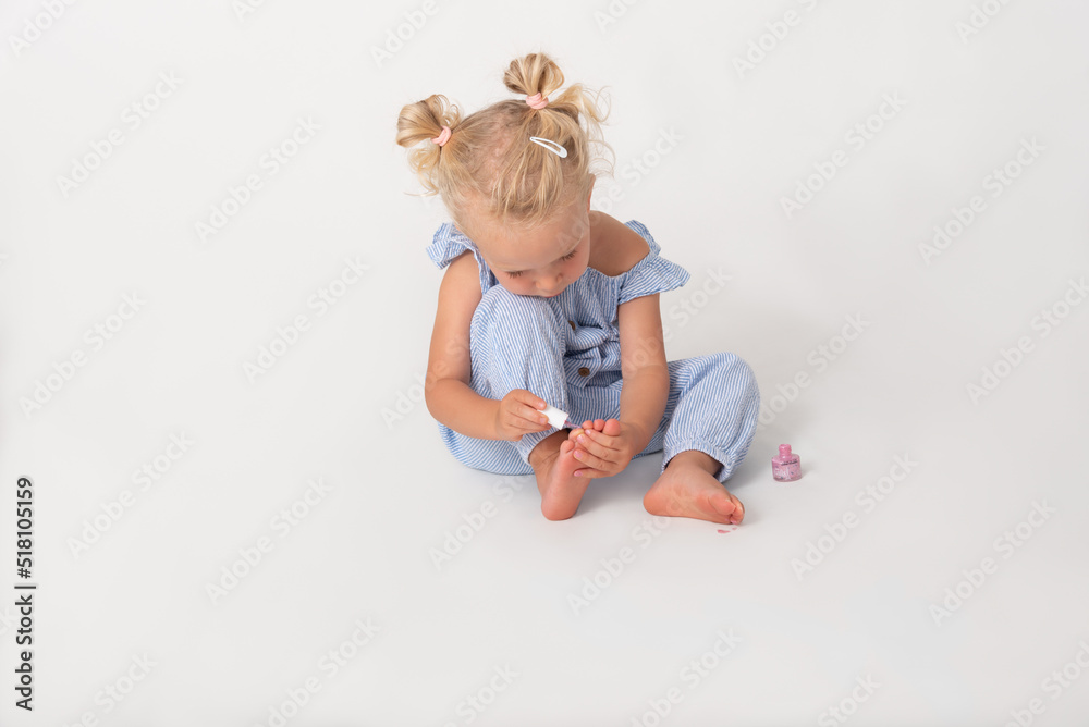 little girl sitting on the floor painting her toenails little girl sitting on the floor painting her toenails