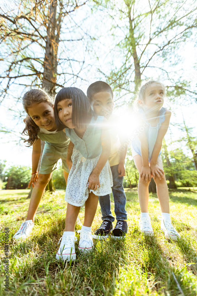 Fototapeta premium Group of asian and caucasian kids having fun in the park