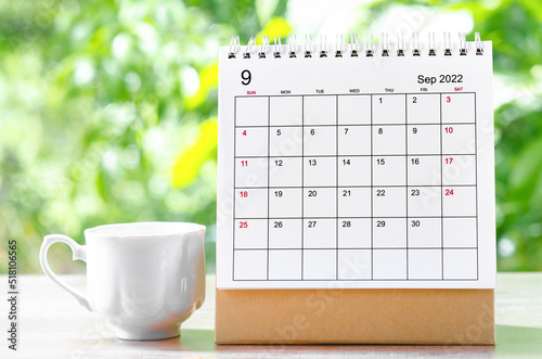 The September 2022 Calendar desk for organizer to plan and reminder on wooden table on nature background.