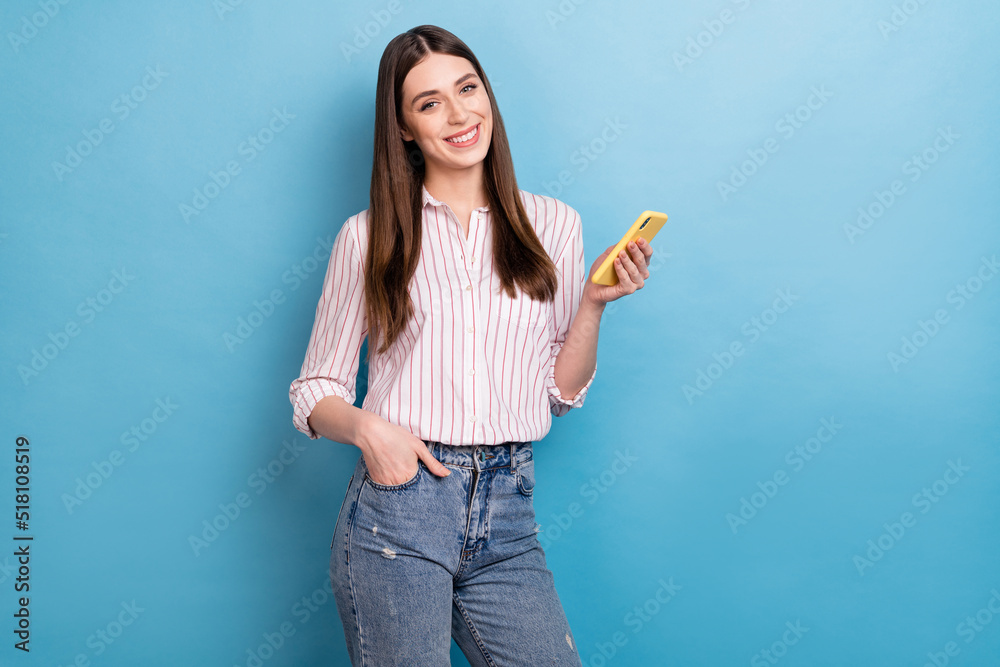 Portrait of attractive trendy cheerful girl using device smm application isolated over vivid blue color background Portrait of attractive trendy cheerful girl using device smm application isolated over vivid blue color background