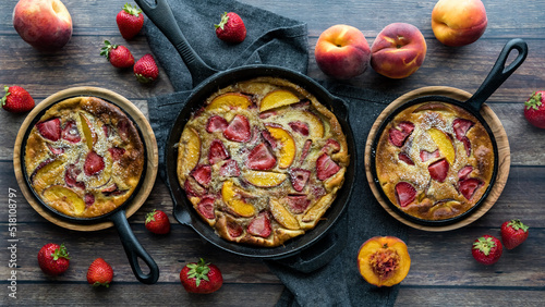Strawberry peach Dutch baby pancakes surrounded by strawberries and peaches.