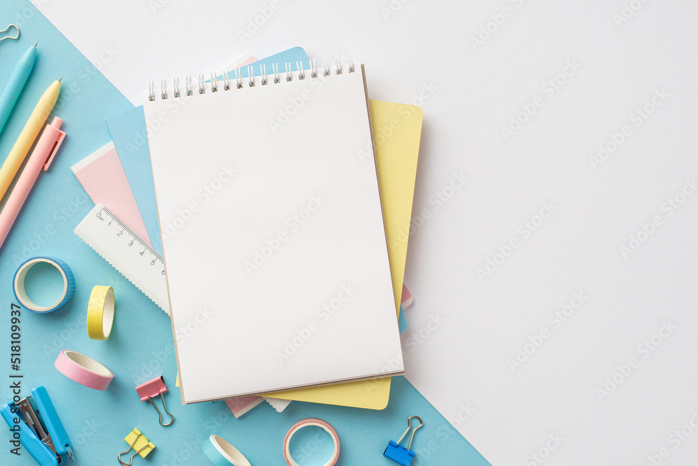 Back to school concept. Top view photo of stack of notebooks pens ruler stapler binder clips and adhesive tape on bicolor blue and white background with blank space Back to school concept. Top view photo of stack of notebooks pens ruler stapler binder clips and adhesive tape on bicolor blue and white background with blank space