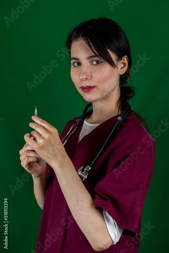 young female nurse holds a syringe with a needle in her hand in medical clothes isolated