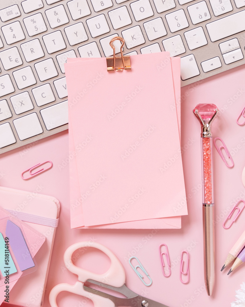 Paper with a clip, Pink school girly accessories and keyboard on pastel pink Top view, mockup Paper with a clip, Pink school girly accessories and keyboard on pastel pink Top view, mockup