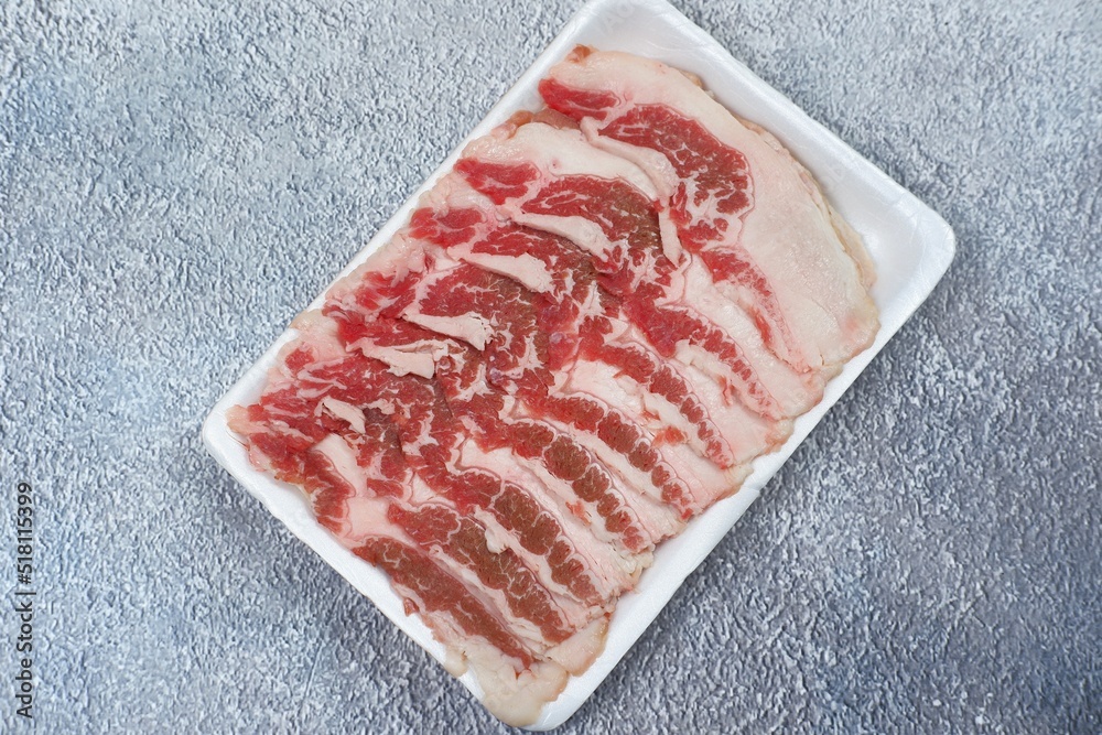fresh beef raw sliced on grey texture background. served for Sukiyaki and Shabu or Yakiniku
