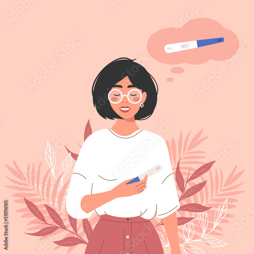 A happy young mum holds up a positive two-strip pregnancy test. The smile of a girl planning a baby. Pregnancy, the concept of medicine.