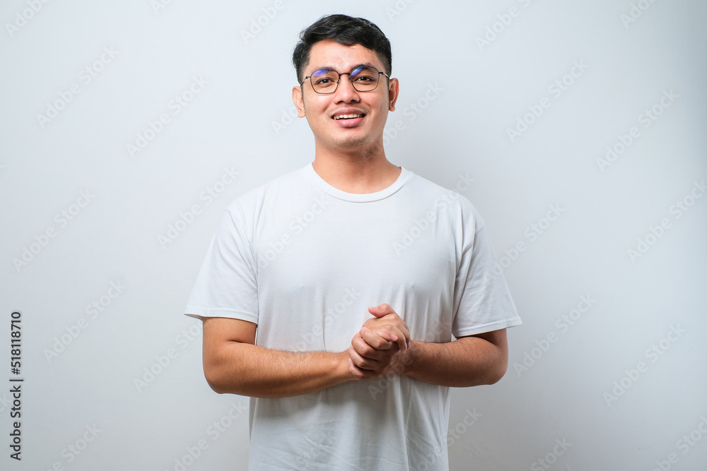Young handsome man with hands together and crossed fingers smiling relaxed and cheerful. Success and optimistic Young handsome man with hands together and crossed fingers smiling relaxed and cheerful. Success and optimistic