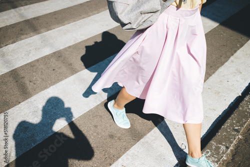 Young woman wearing pink skirt and blue sneakers