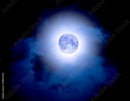 Blue full moon in cloudy sky. June 13, 2022