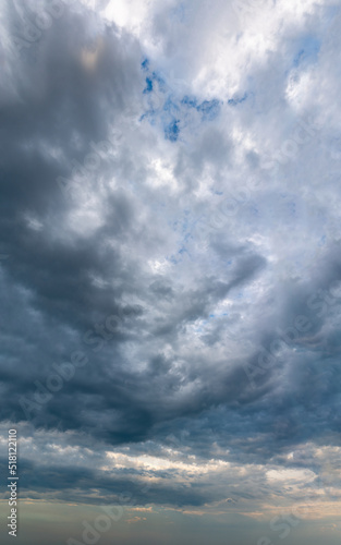 Fantastic thunderclouds at sunrise, vertical panorama