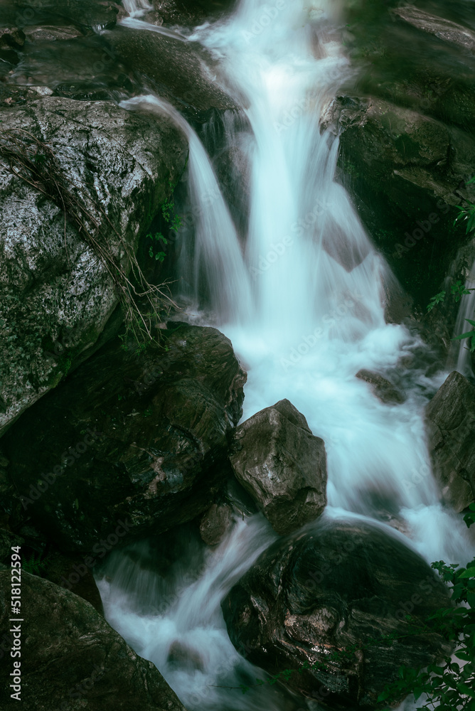 Obraz premium Long exposure photograph of a waterfall surrounded by big rocks