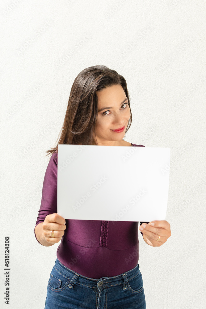 Mulher morena bonita e sorridente com cartaz para publicidade Mulher morena bonita e sorridente com cartaz para publicidade