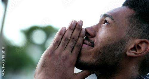 Spiritual young black African man praying to GOD. Person looking to sky with HOPE and FAITH