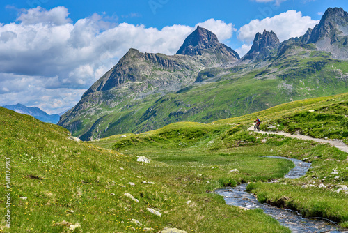 nice active senior woman riding her electric mountain bike in the silvretta mountain range above barrier lake Kopssee,near Gaschurn, Tyrol, Austria