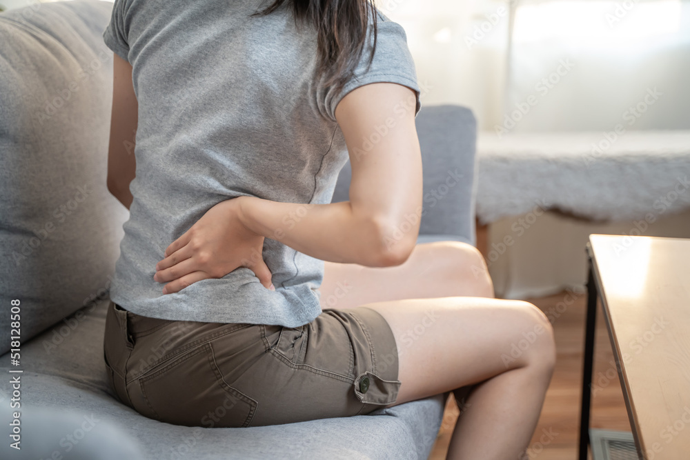 Woman suffering from back ache on the bed and sofa while working housework, healthcare and problem concept Woman suffering from back ache on the bed and sofa while working housework, healthcare and problem concept