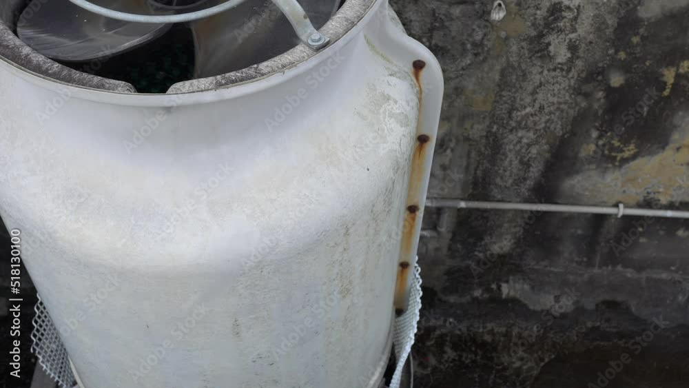 Large air-conditioning compressor is hung on the wall. Appearance is a little rusty. Large air-conditioning compressor is hung on the wall. Appearance is a little rusty.