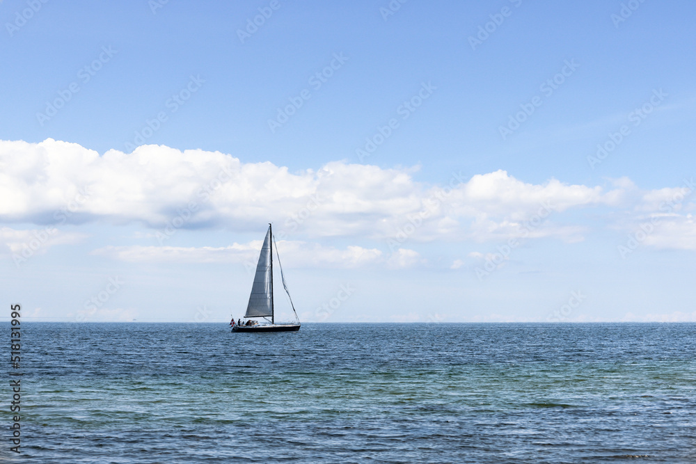 Fototapeta premium Beautiful seascape. Sailboat floats on the blue sea.
