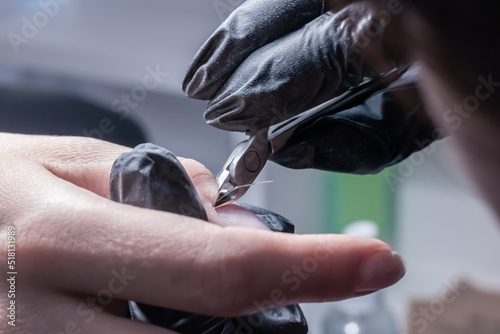 The process of manicure in a beauty salon close-up. Cuticle removal