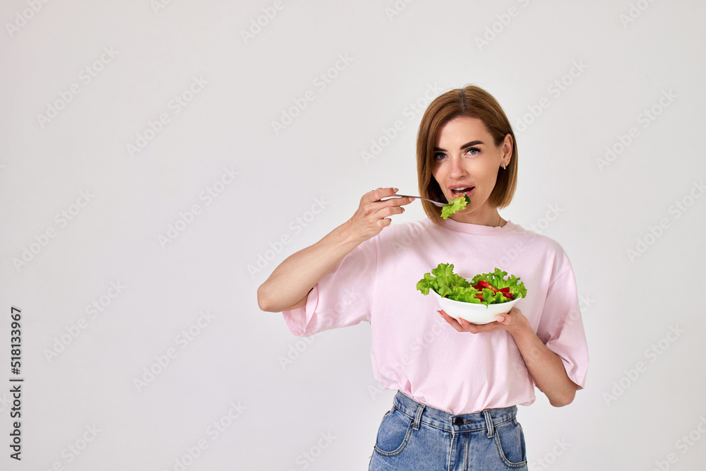beautiful woman eating fresh vegetable salad on white background beautiful woman eating fresh vegetable salad on white background