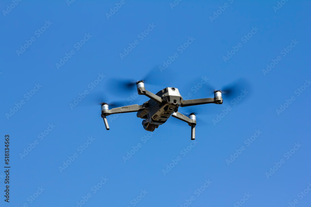 View on quadcopter drone flying in the blue sky. View on quadcopter drone flying in the blue sky.
