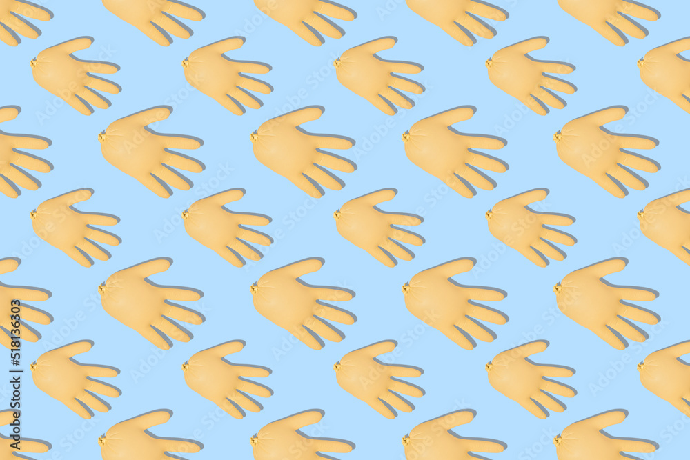 Fototapeta premium Seamless pattern with inflated yellow medical gloves on a blue background. Prevention and protection of coronavirus, covid-19. Healthcare concept. Abstract background.