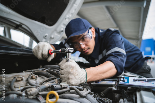A uniformed maintenance technician is working on a vehicle inspection service. Vehicle repair and maintenance concept. photo