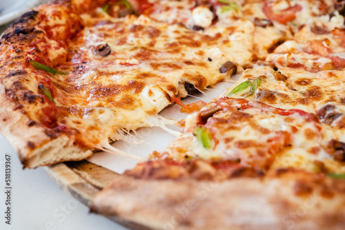 Greek pizza in outdoor restaurant. Tourist dinner in Agios Nikolaos in Crete, Greece. Summer vacation concept.