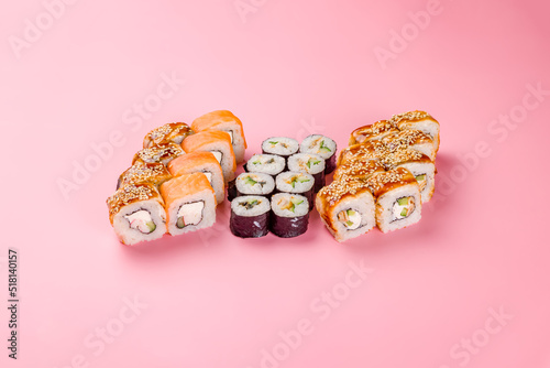 set of different rolls and sushi on pink background