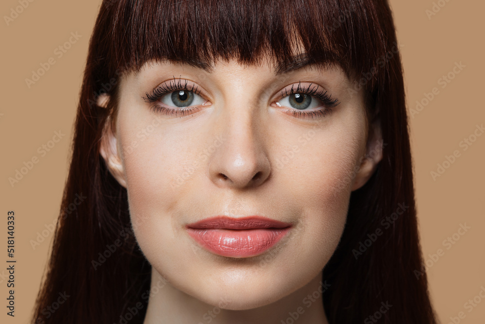 Attractive caucasian woman with healthy skin holding hands near face and smiling on camera over beige studio background. Natural beauty and skin care concept. Attractive caucasian woman with healthy skin holding hands near face and smiling on camera over beige studio background. Natural beauty and skin care concept.