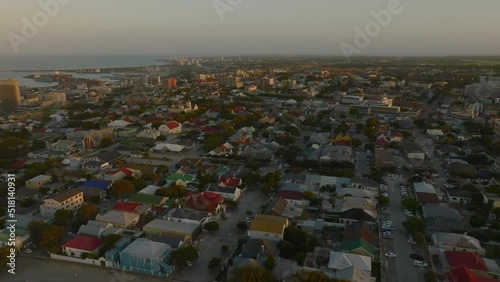 Slide and pan aerial shot of buildings in residential urban neighbourhood at sunset. Port Elisabeth, South Africa