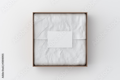 Square gift box mock up. Cardboard gift box with blank label or business card on wrapping paper. White background. View directly above.