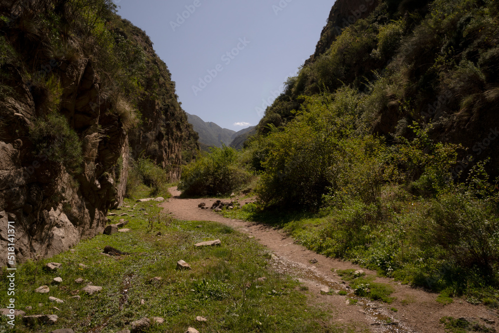 Hiking in the mountains. View of the empty path across the hills and canyon in a sunny day, 