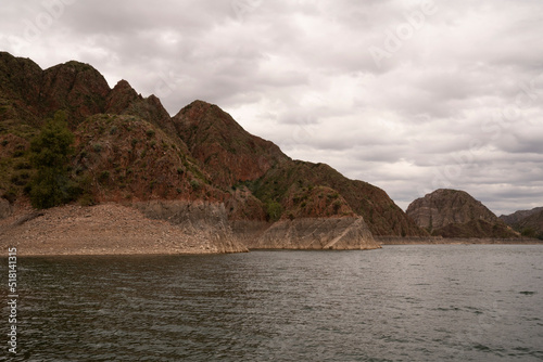 View of the rocky cliffs and lake in a cloudy day.