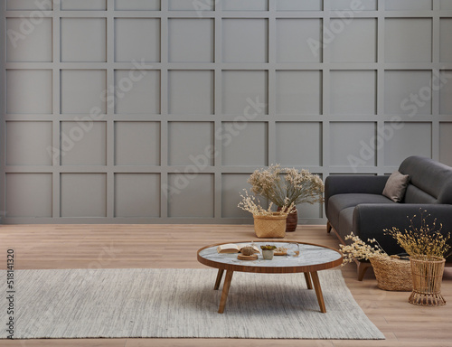Grey room decorative wall background, dark blue sofa, middle table, blanket pillow style, vase of cotton flower and carpet, orange lamp, interior decoration.