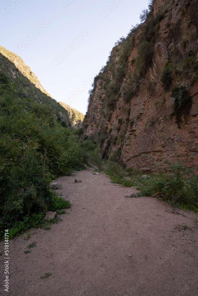 Hiking in the mountains. View of the empty path across the arid desert and rocky canyon.