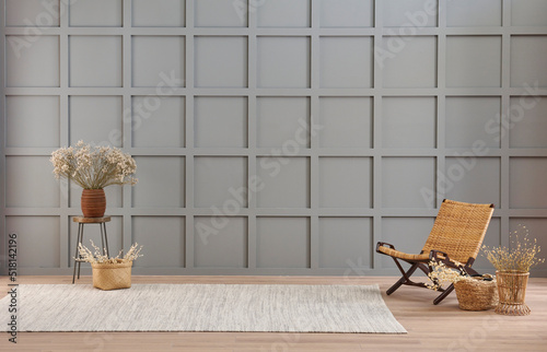 Vase of cotton flower and wicker chair decoration in front of the modern grey wall  carpet style.