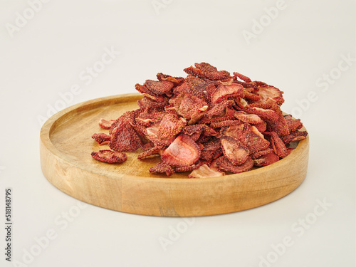 Fresh many strawberry dried fruit on the white background, in the wooden cup.