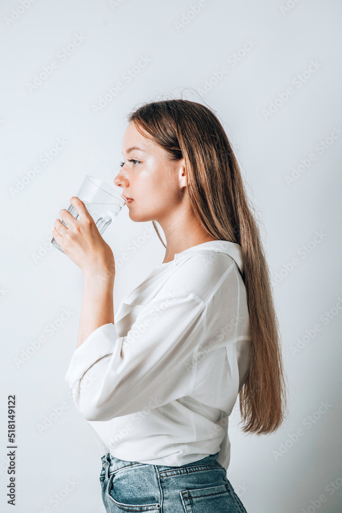 Asian girl with purple drinks water from a plastic bottle on a white isolated background. Generation Z. The concept of thirst Asian girl with purple drinks water from a plastic bottle on a white isolated background. Generation Z. The concept of thirst
