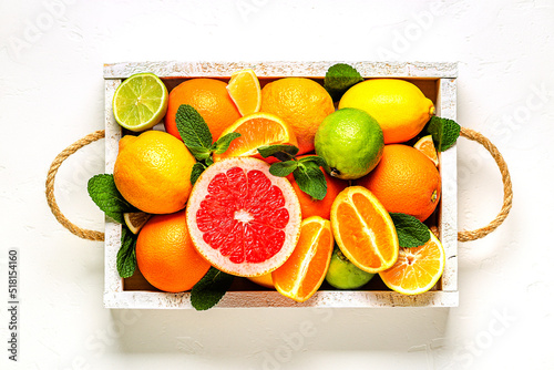 Fresh citrus fruits with leaves  lemons  oranges  mandarins  grapefruit  lime in wooden box