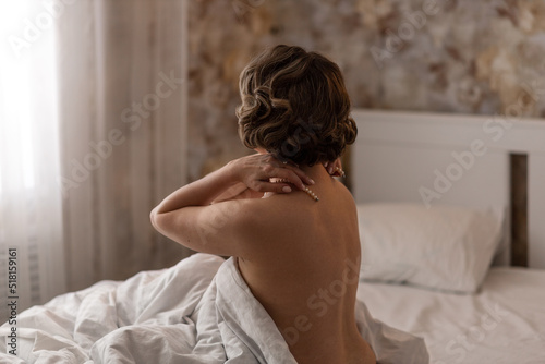 Naked beautiful girl woke up and enjoys her nakedness in bed in the morning