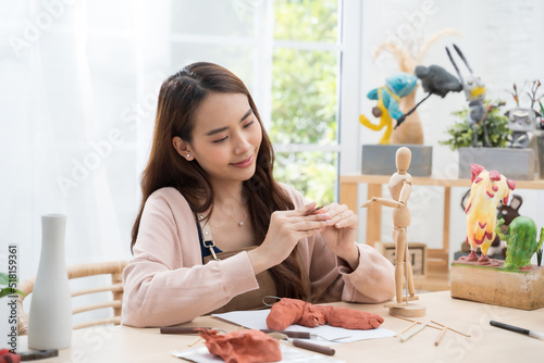 Young Asian girl making a sculpture with modeling clay at home .hobby clay sculpt concept photo