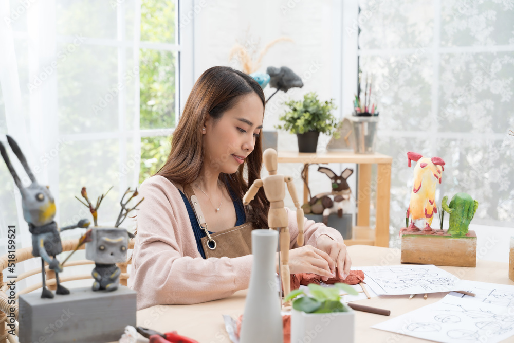 Young Asian girl making a sculpture with modeling clay at home .hobby clay sculpt concept