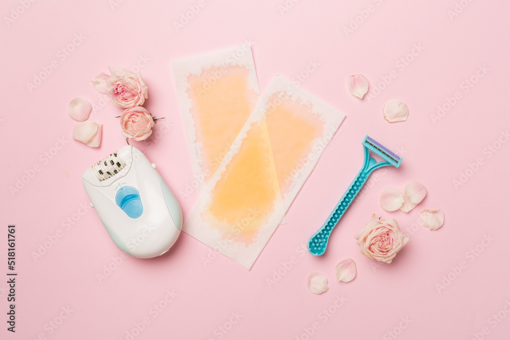 Wax strips, modern epilator and razor with flowers on color background, top view