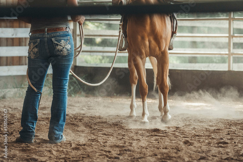Cowgirl working her quarter horse in a rope in the paddock